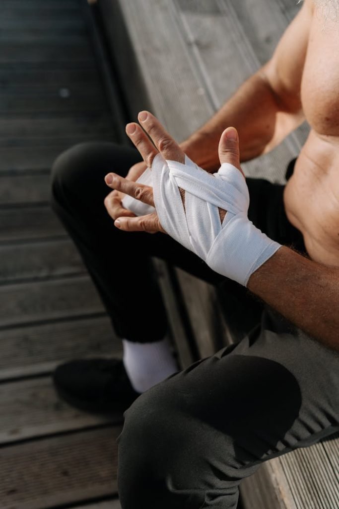 Close-up of athlete wrapping hands with bandages outdoors, highlighting preparation.