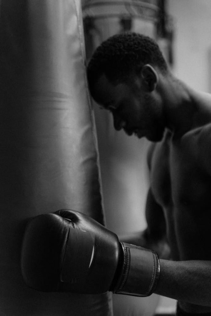 A focused boxer in the gym preparing for an intense training session, captured in black and white.
